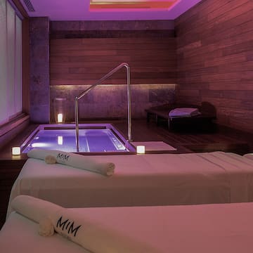 a room with two beds and a hot tub