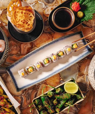 a plate of sushi with chopsticks