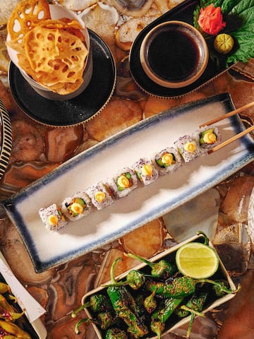a plate of sushi with chopsticks