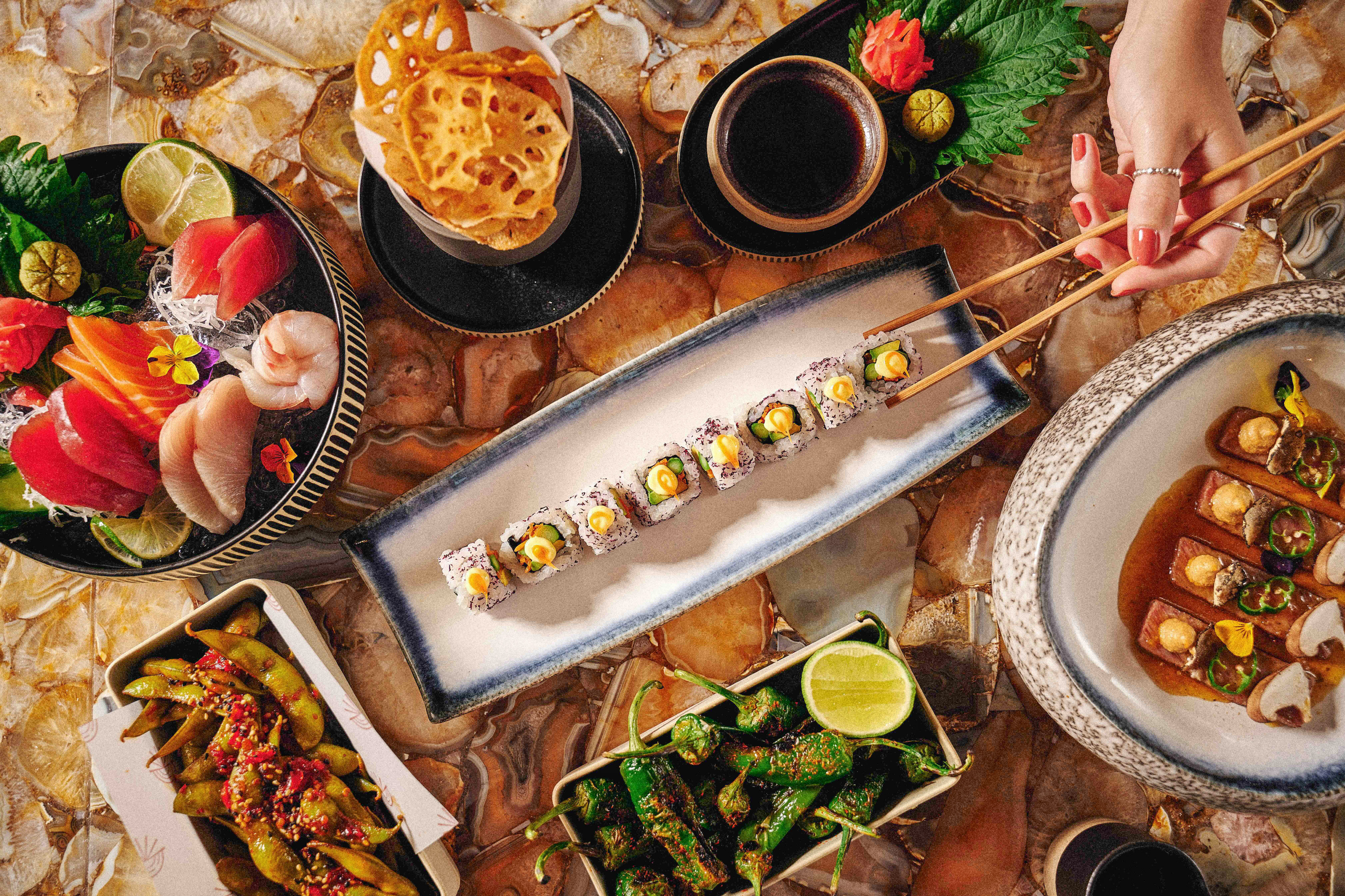 a plate of sushi with chopsticks