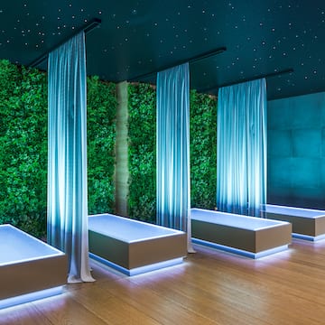 a room with white beds and green plants