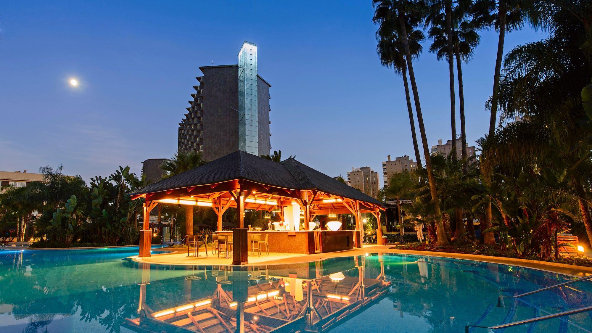 a pool with a gazebo and palm trees