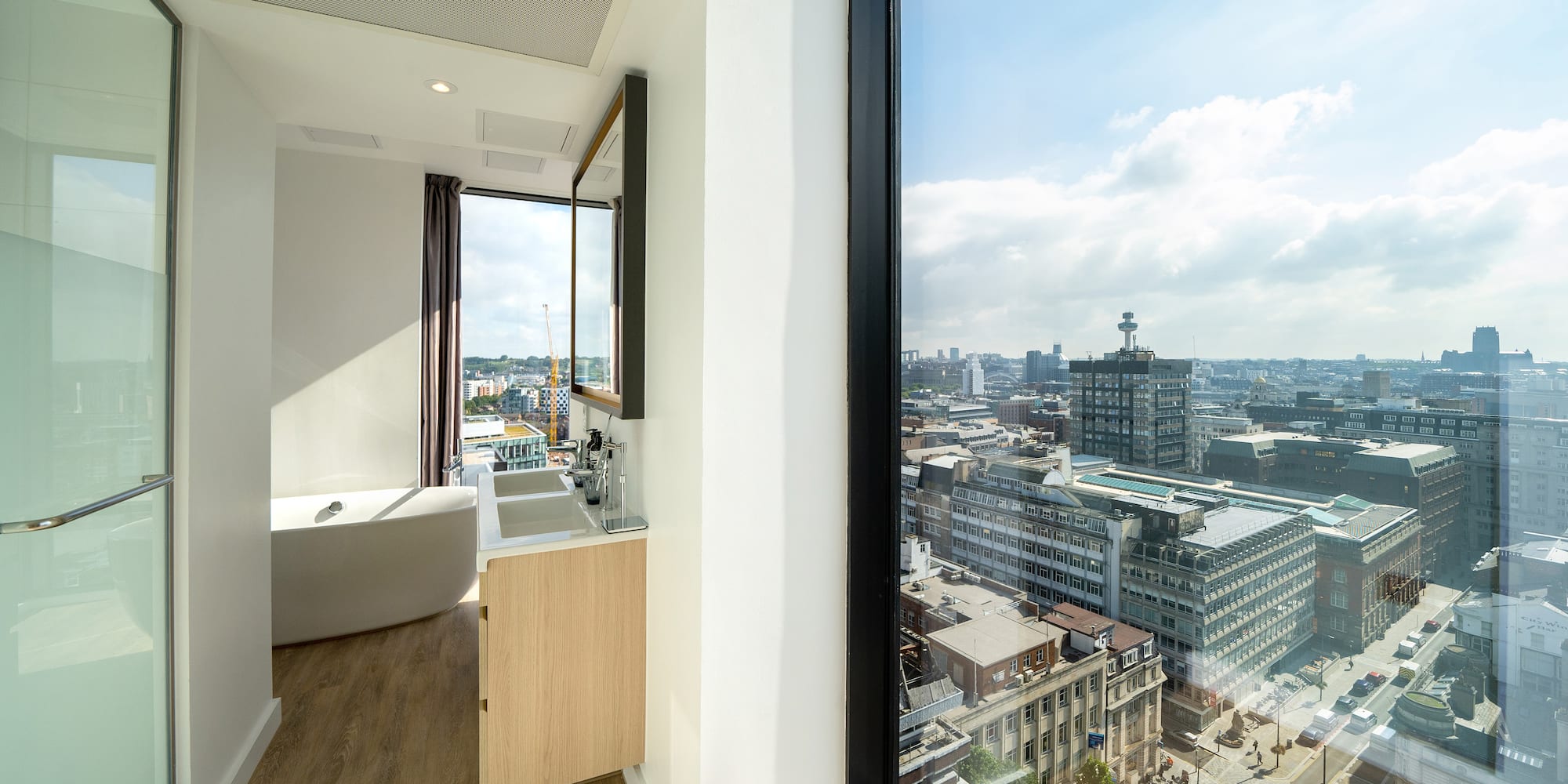 a bathroom with a large window overlooking a city
