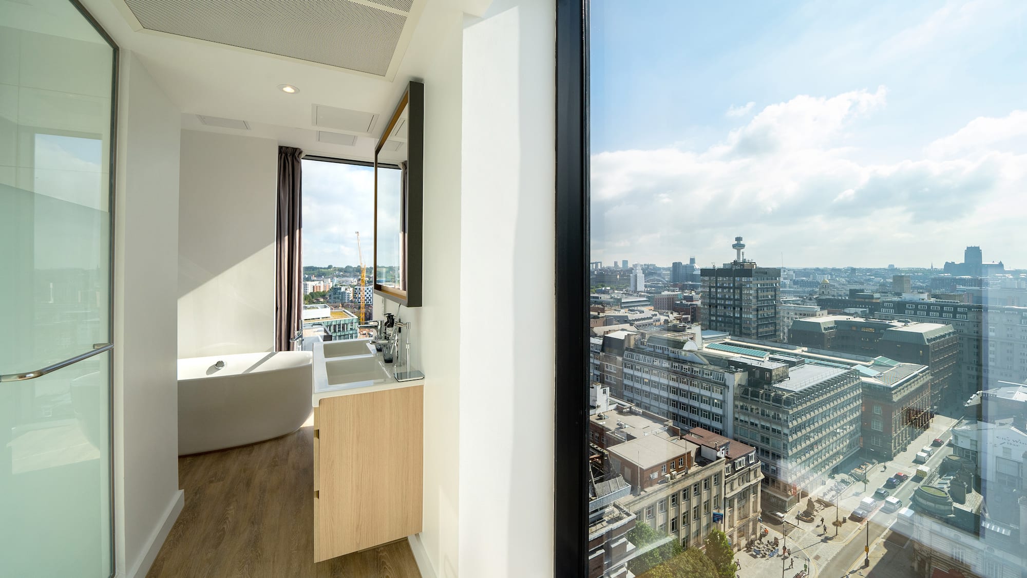 a bathroom with a large window overlooking a city