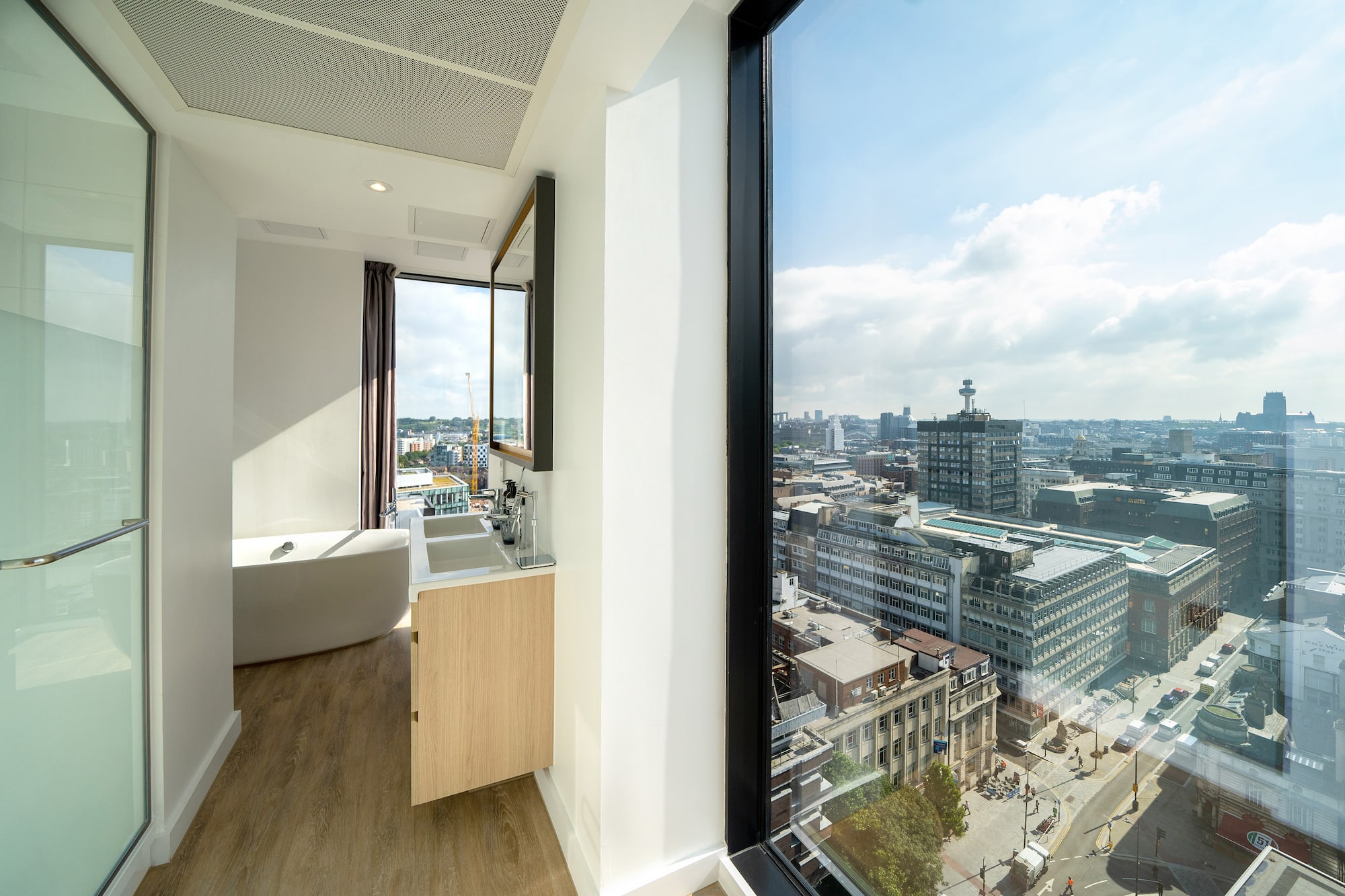a bathroom with a large window overlooking a city