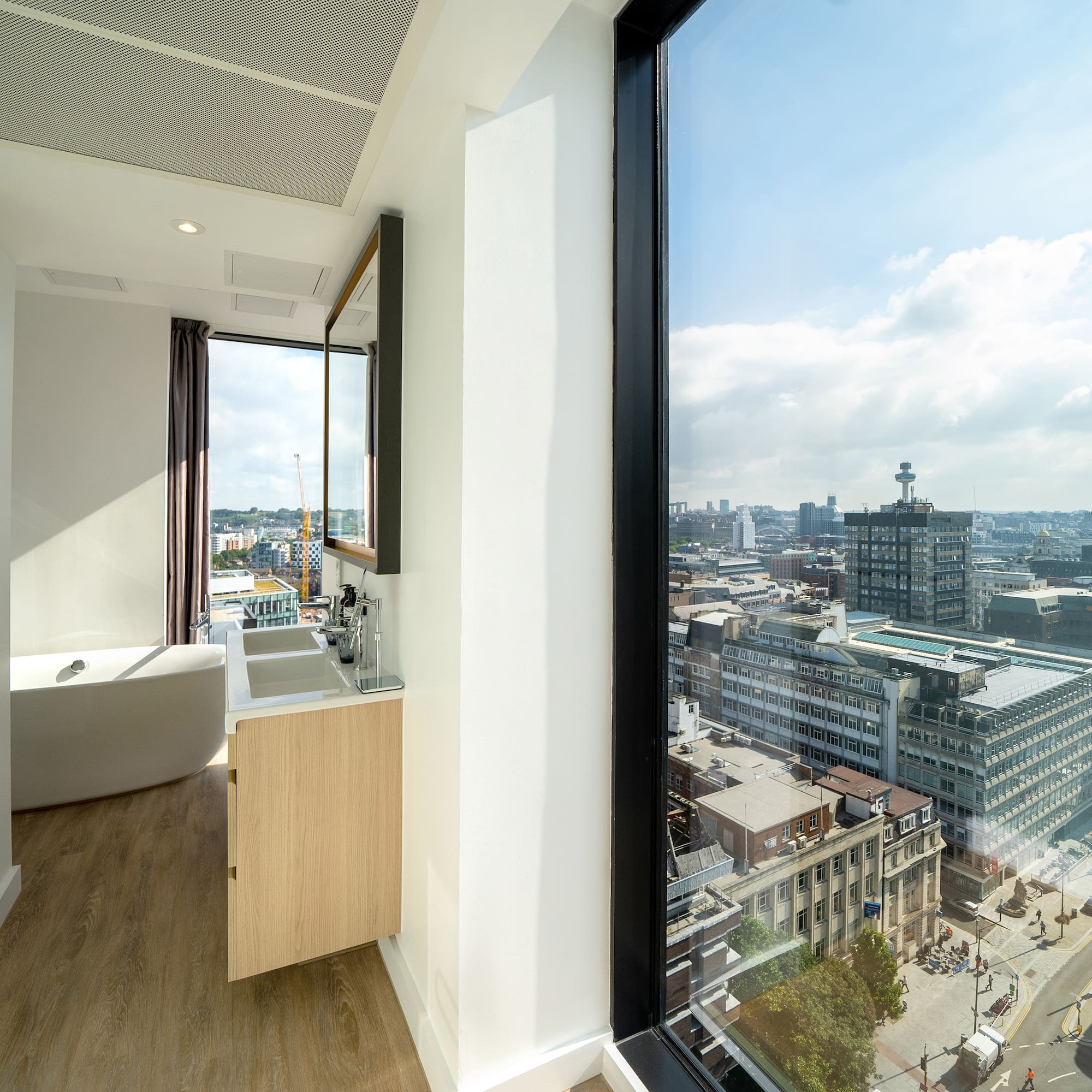 a bathroom with a large window overlooking a city