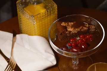 a plate of desserts and glasses of orange juice