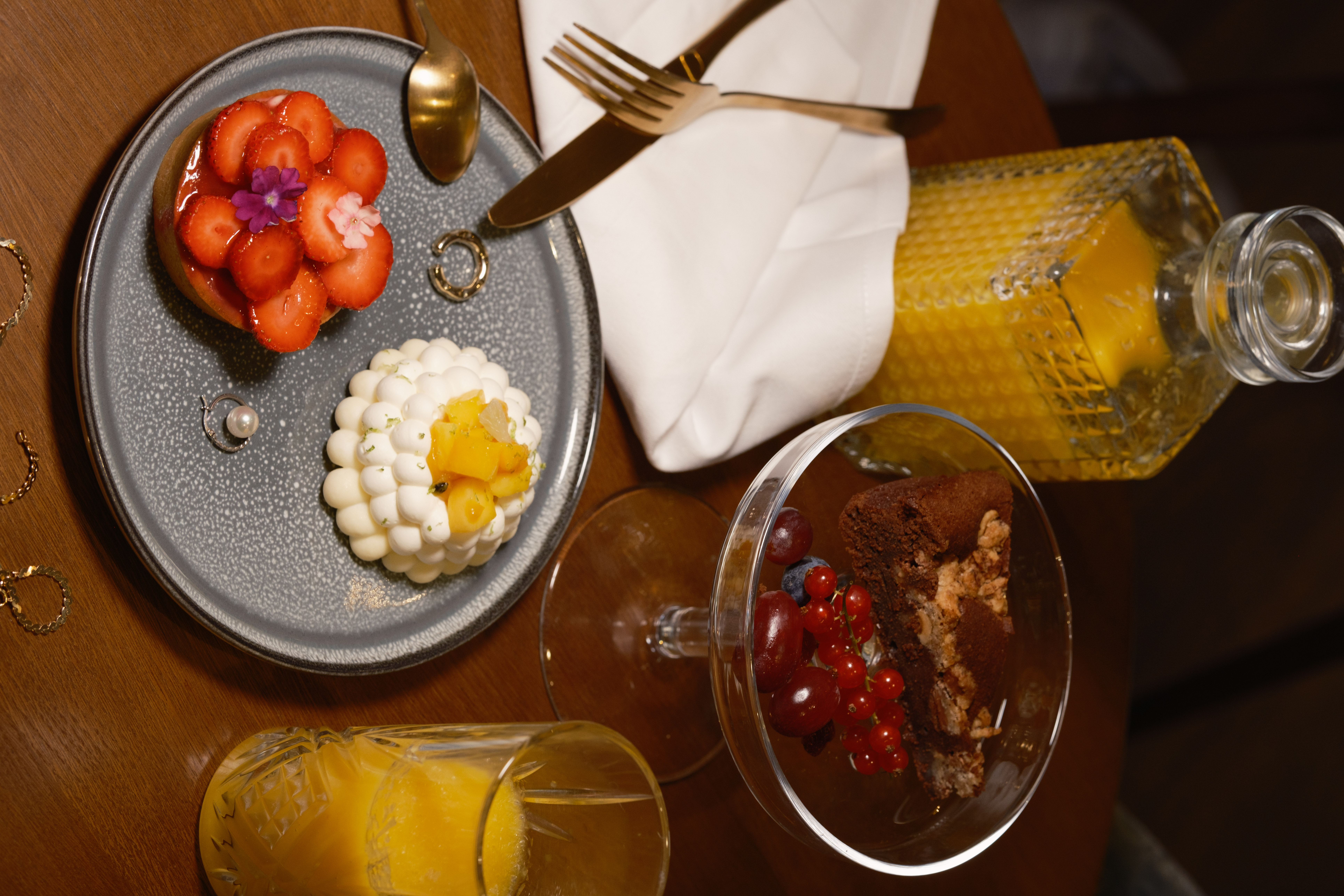 a plate of desserts and glasses of orange juice