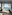 Outdoor restaurant patio with pergola, poolside view of ocean, beach, and palm trees.
