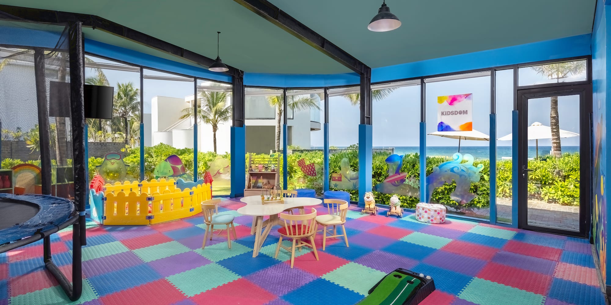 a room with a playroom with a play area and a pool