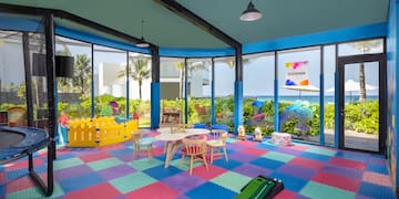a room with a playroom with a play area and a pool