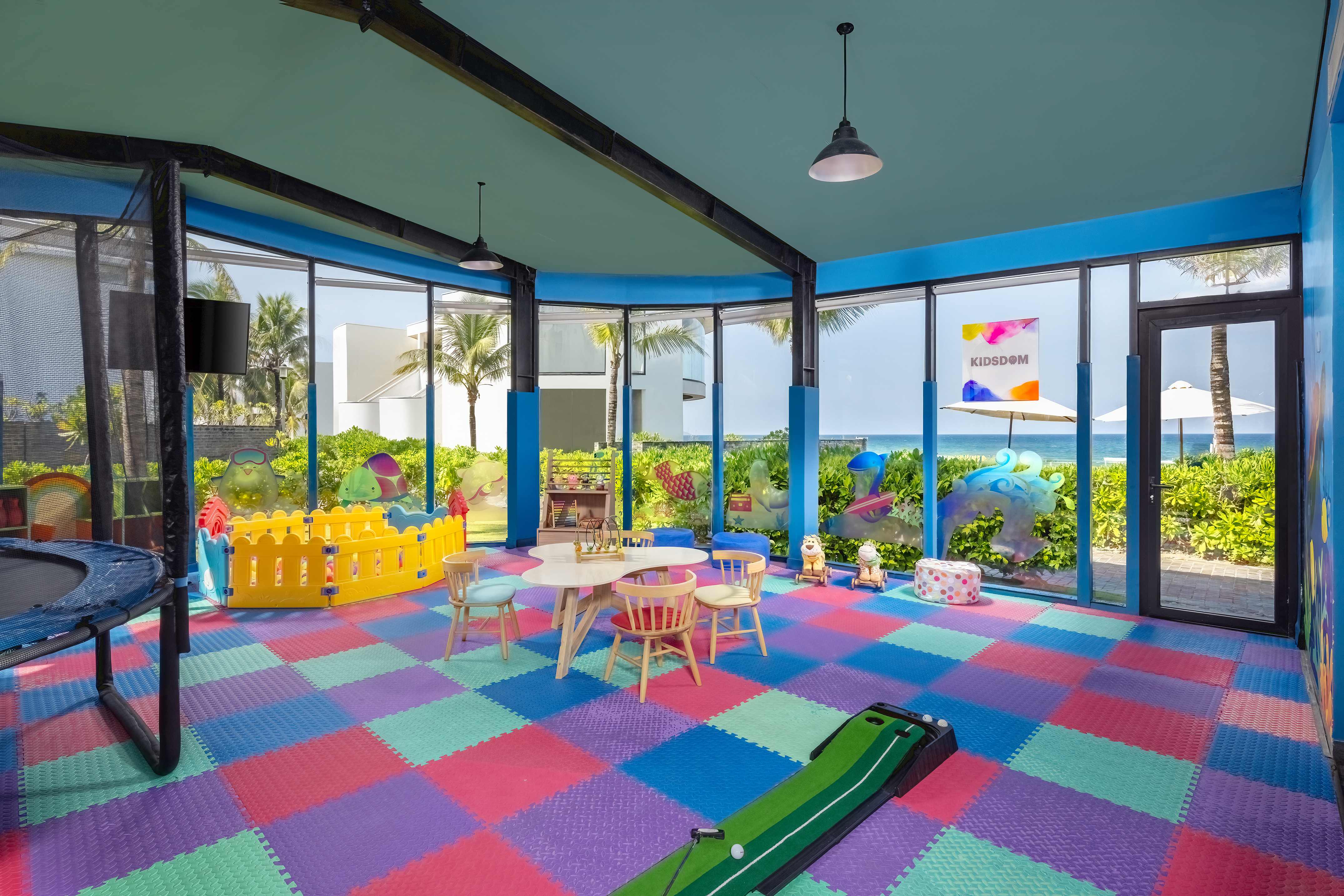 a room with a playroom with a play area and a pool