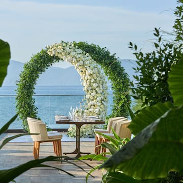 a table with chairs and a table with flowers around it