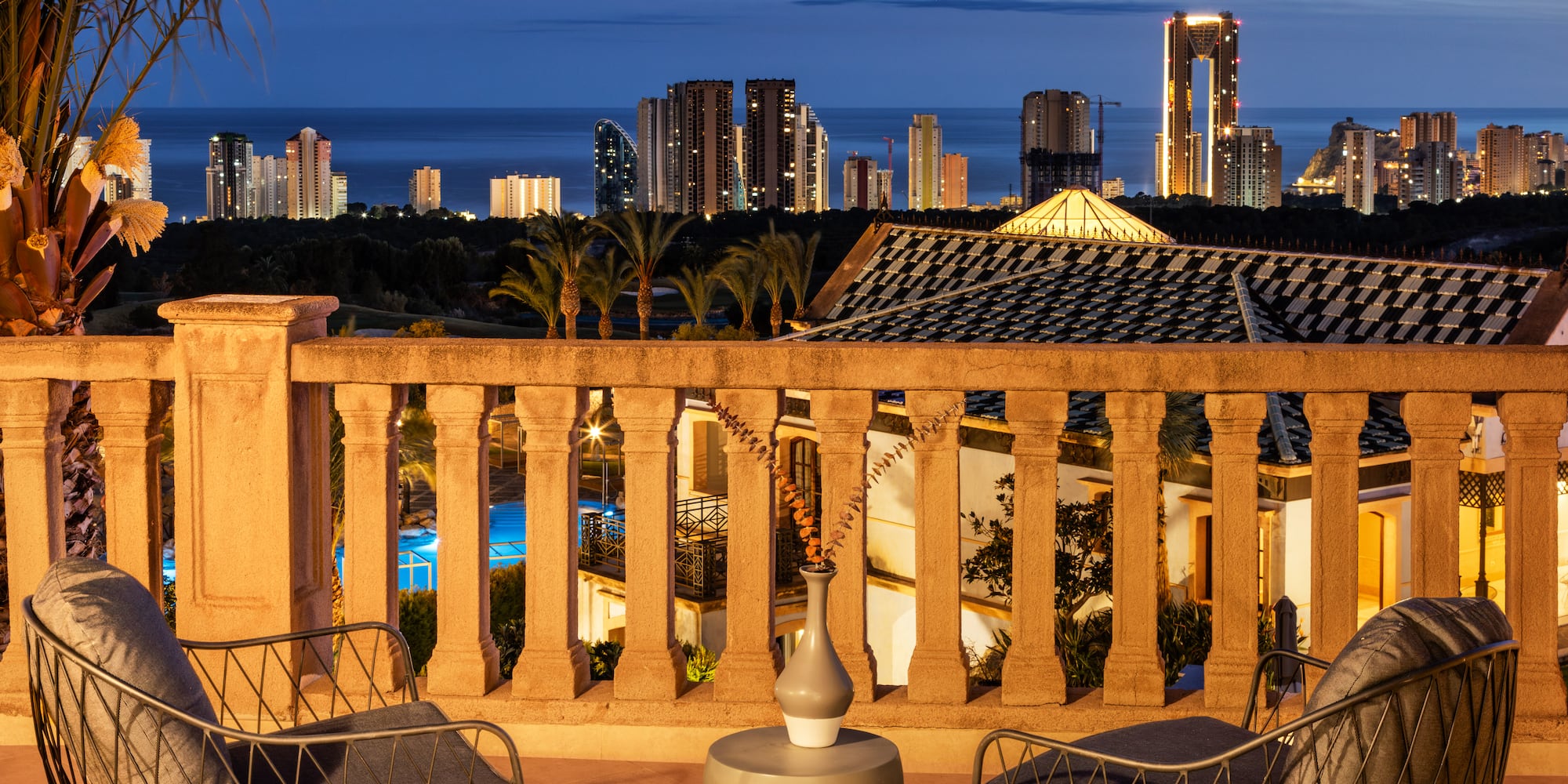 a balcony with chairs and a city skyline