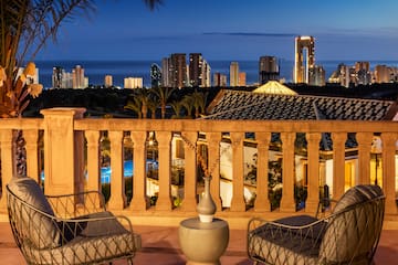 a balcony with chairs and a city skyline