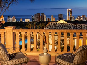 a balcony with chairs and a city skyline