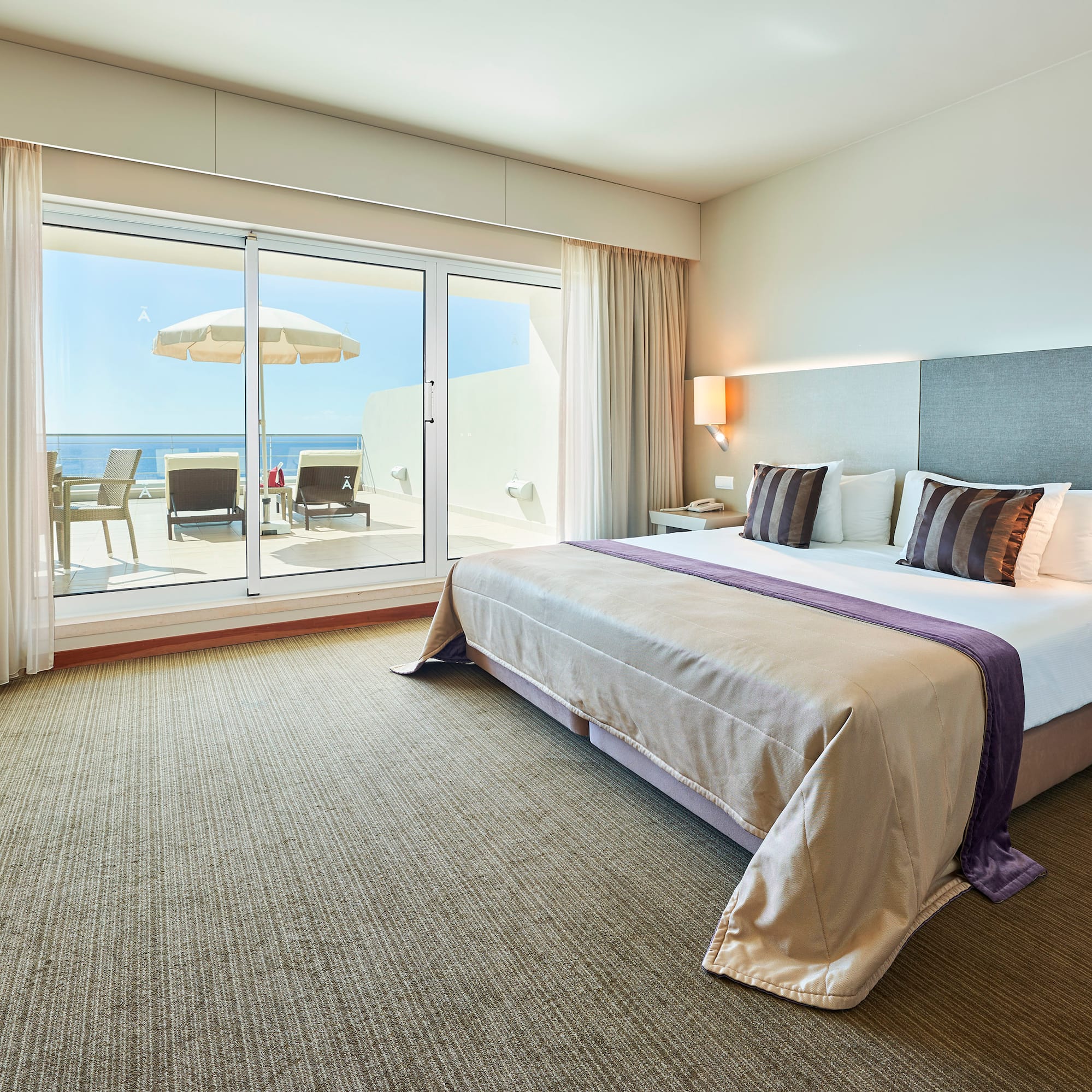 a bedroom with a large bed and a glass door