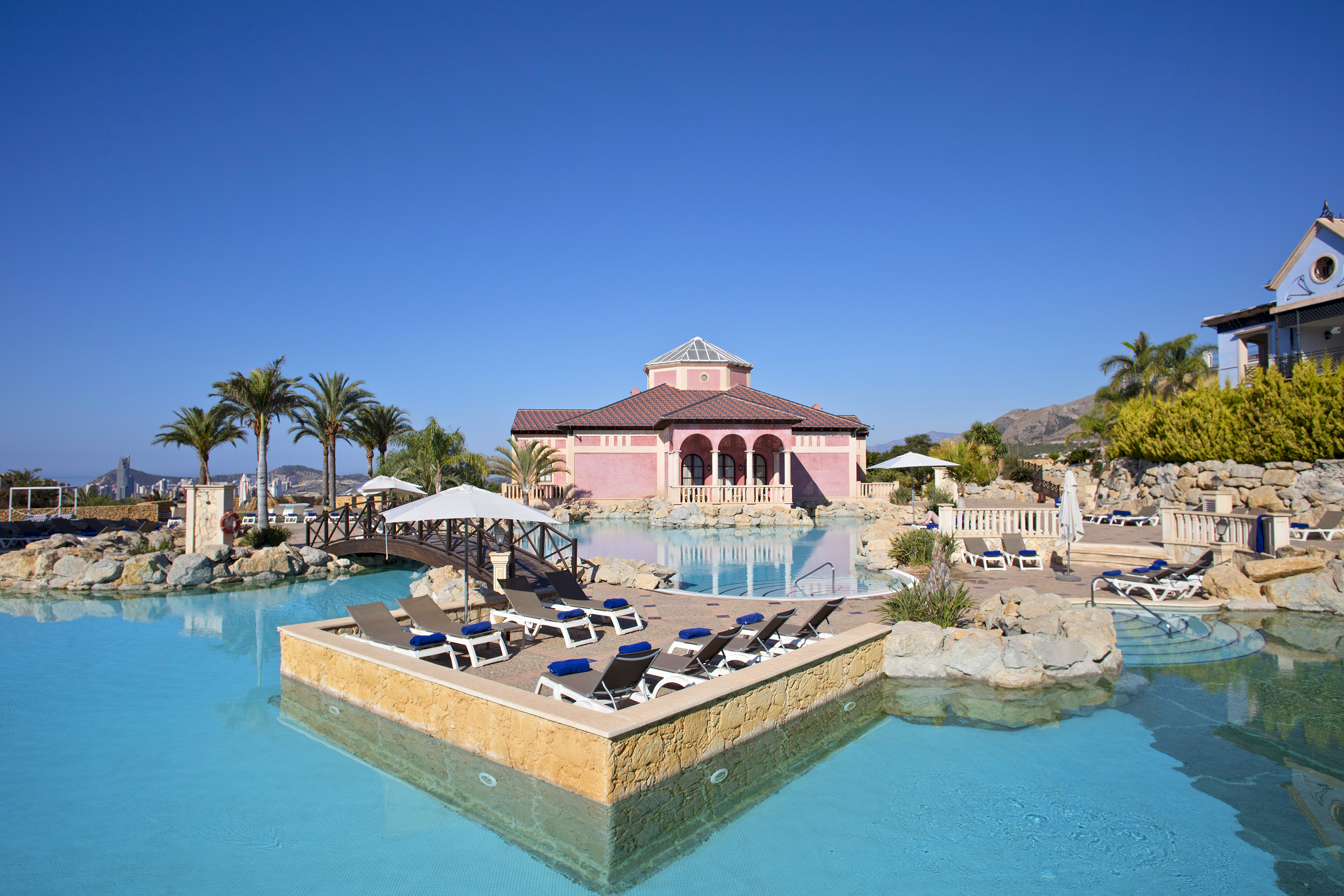a pool with lounge chairs and a building in the background