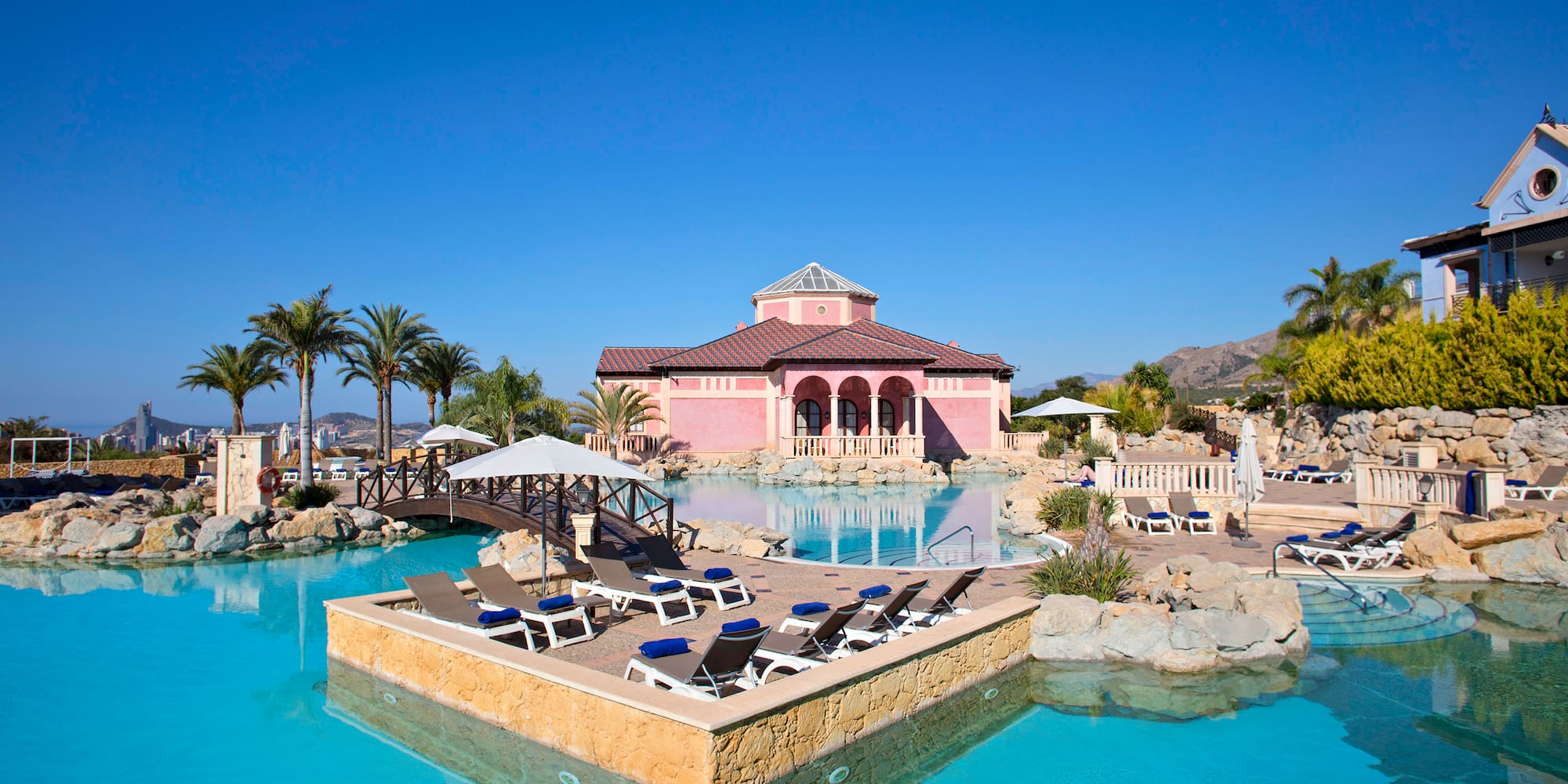 a pool with lounge chairs and a building in the background