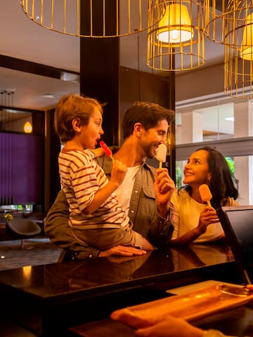 a man and woman holding popsicles and smiling at a counter