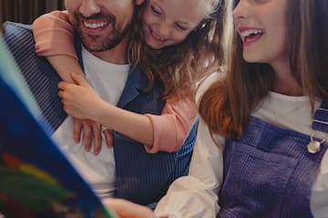 a man and two girls looking at a book