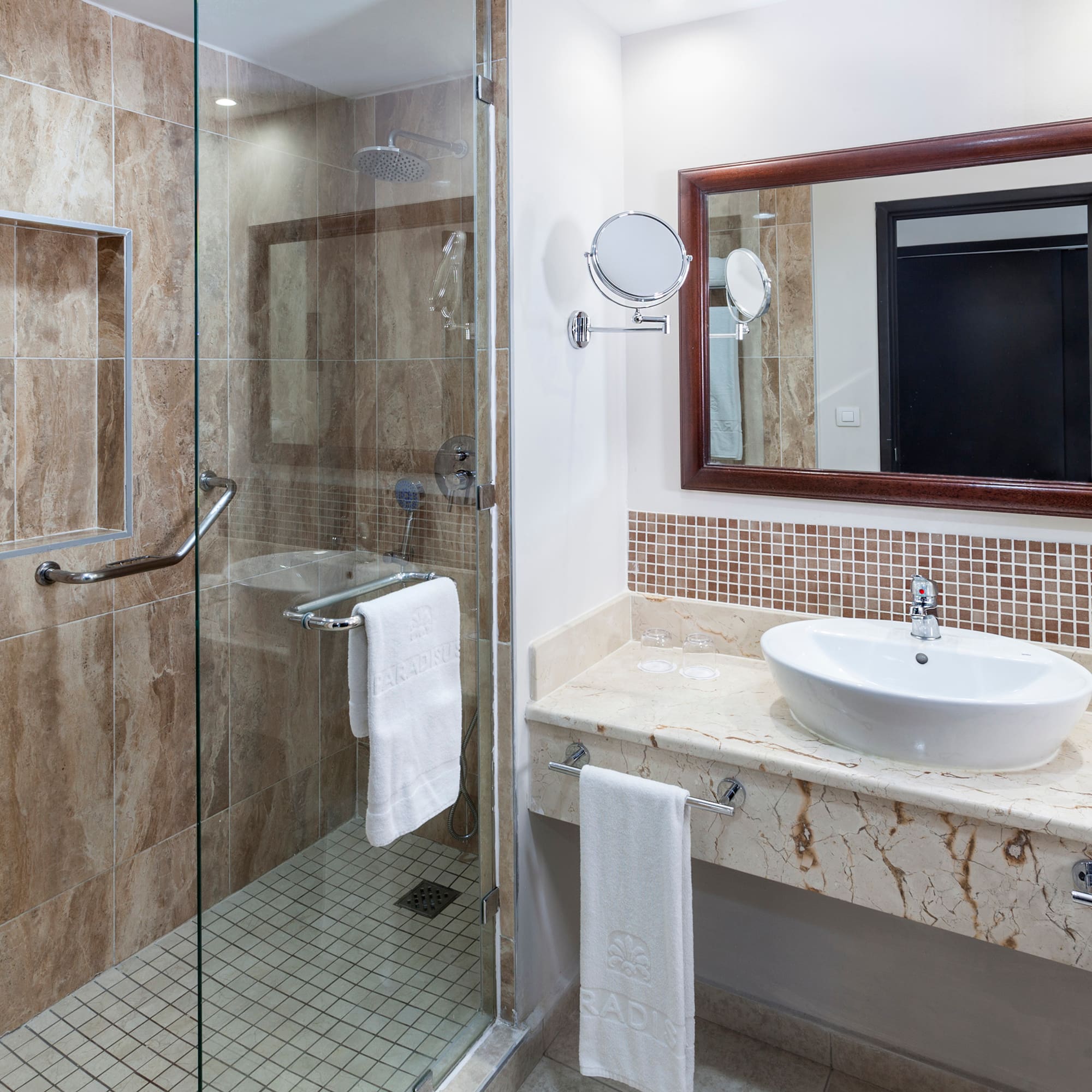 a bathroom with a glass shower and sink