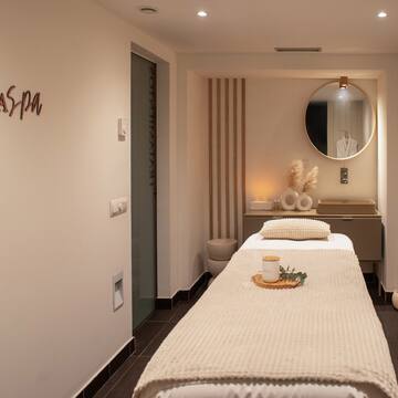 a massage room with a mirror and a bed