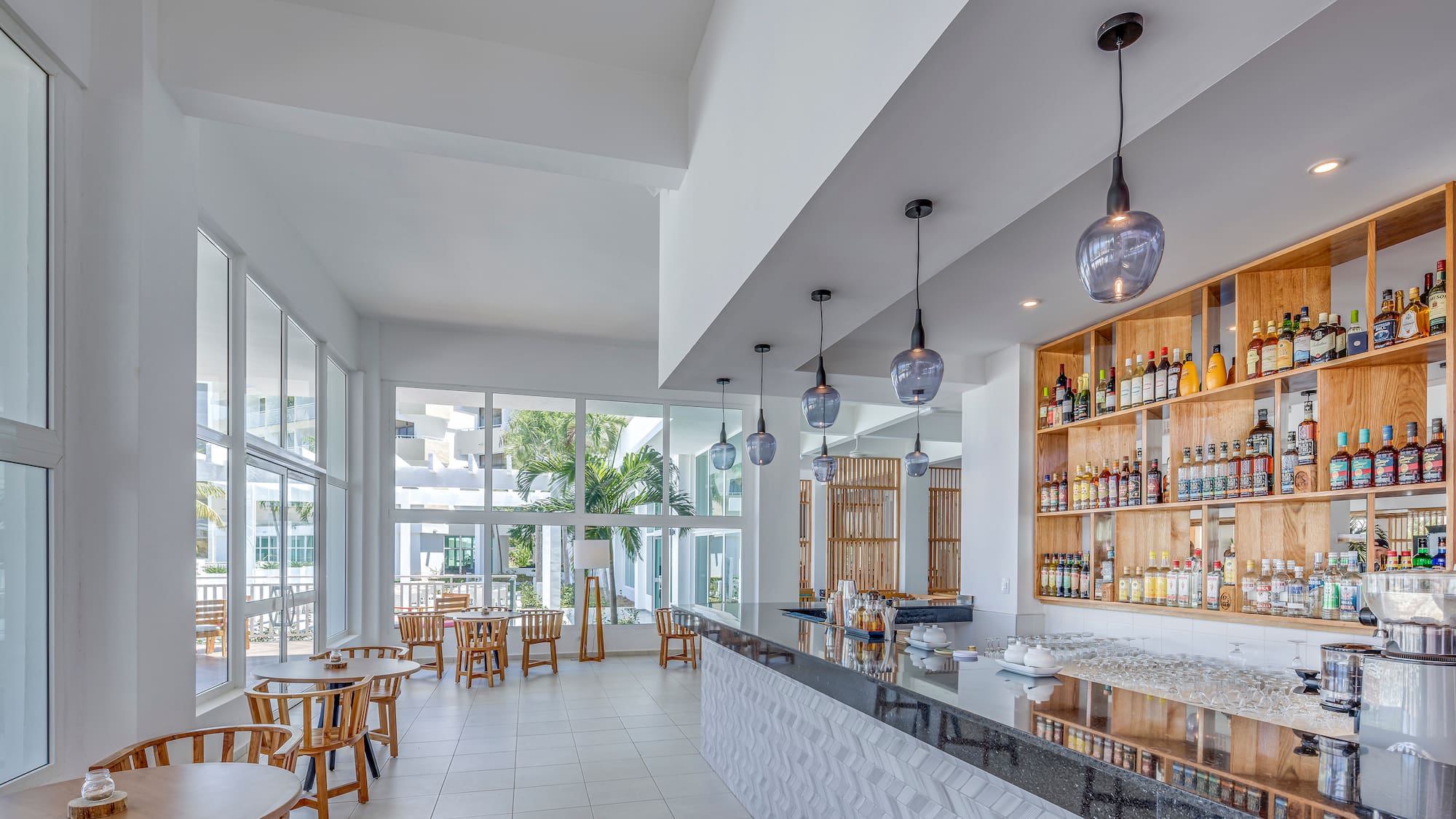 a room with a bar and tables and chairs