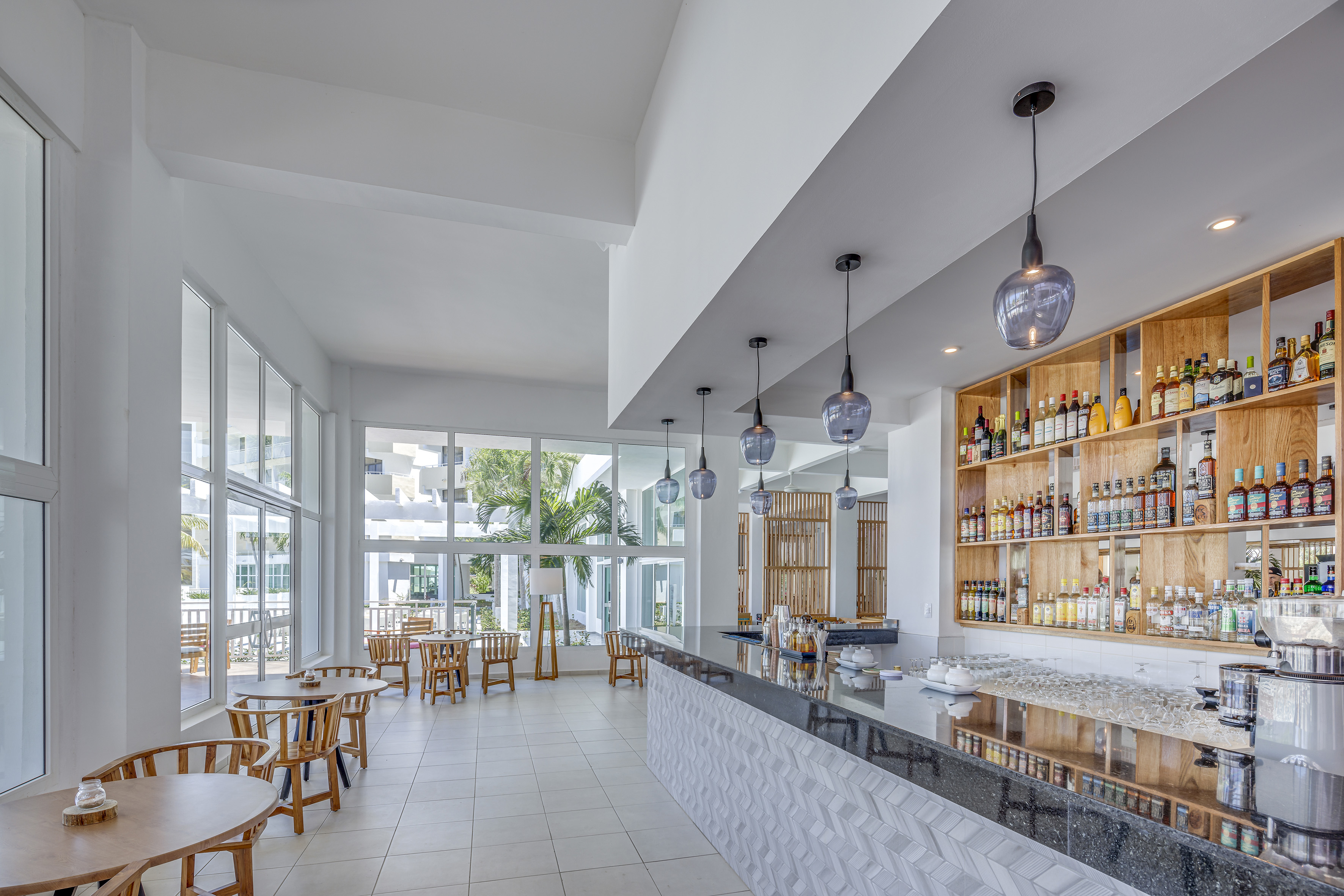 a room with a bar and tables and chairs