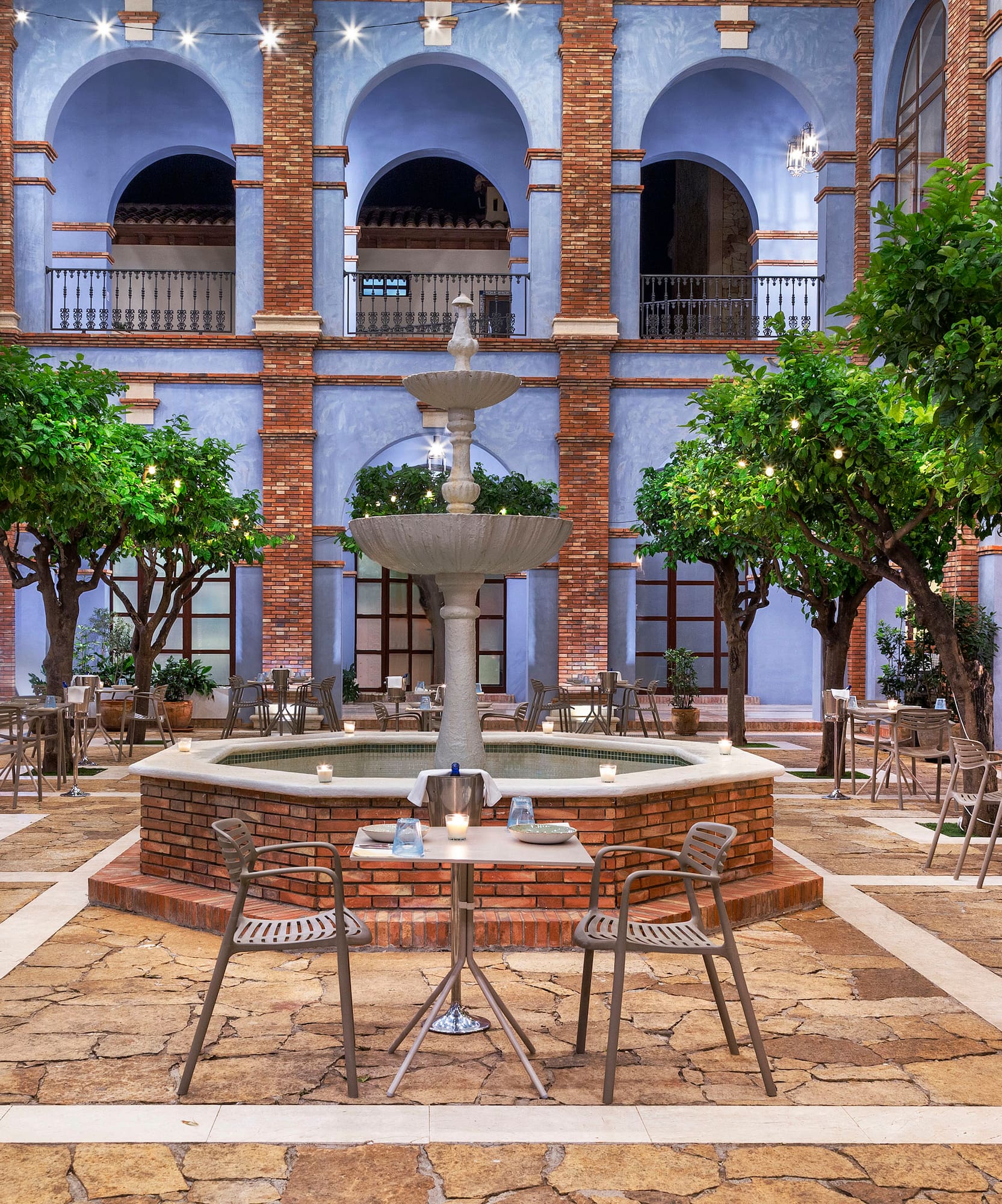 a courtyard with a fountain and trees