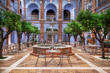 a courtyard with a fountain and trees