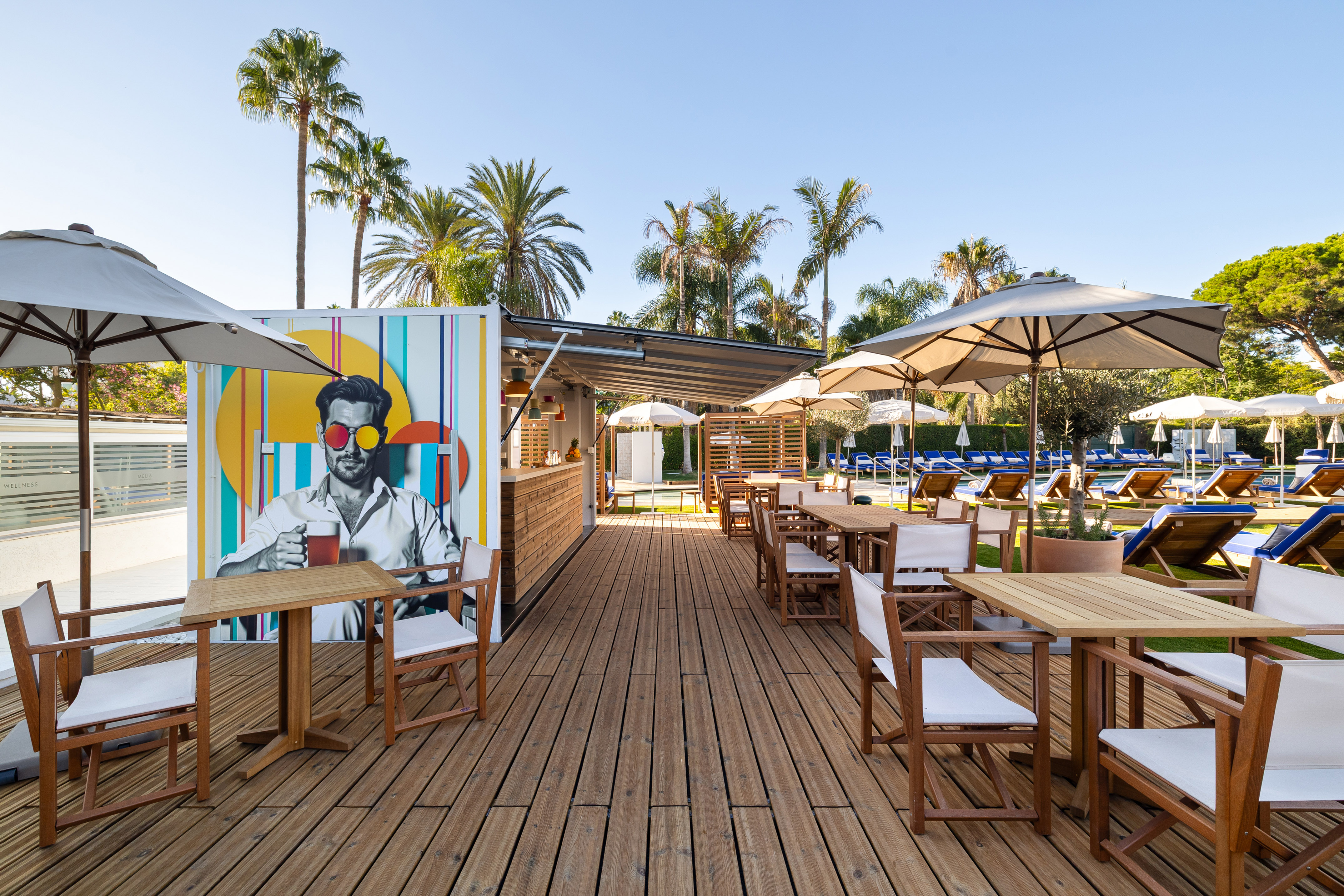 a wooden deck with tables and umbrellas