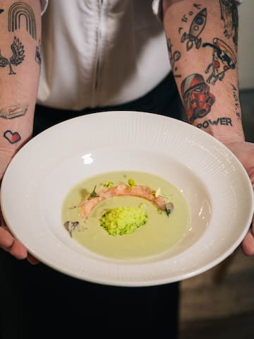 a person holding a plate of soup