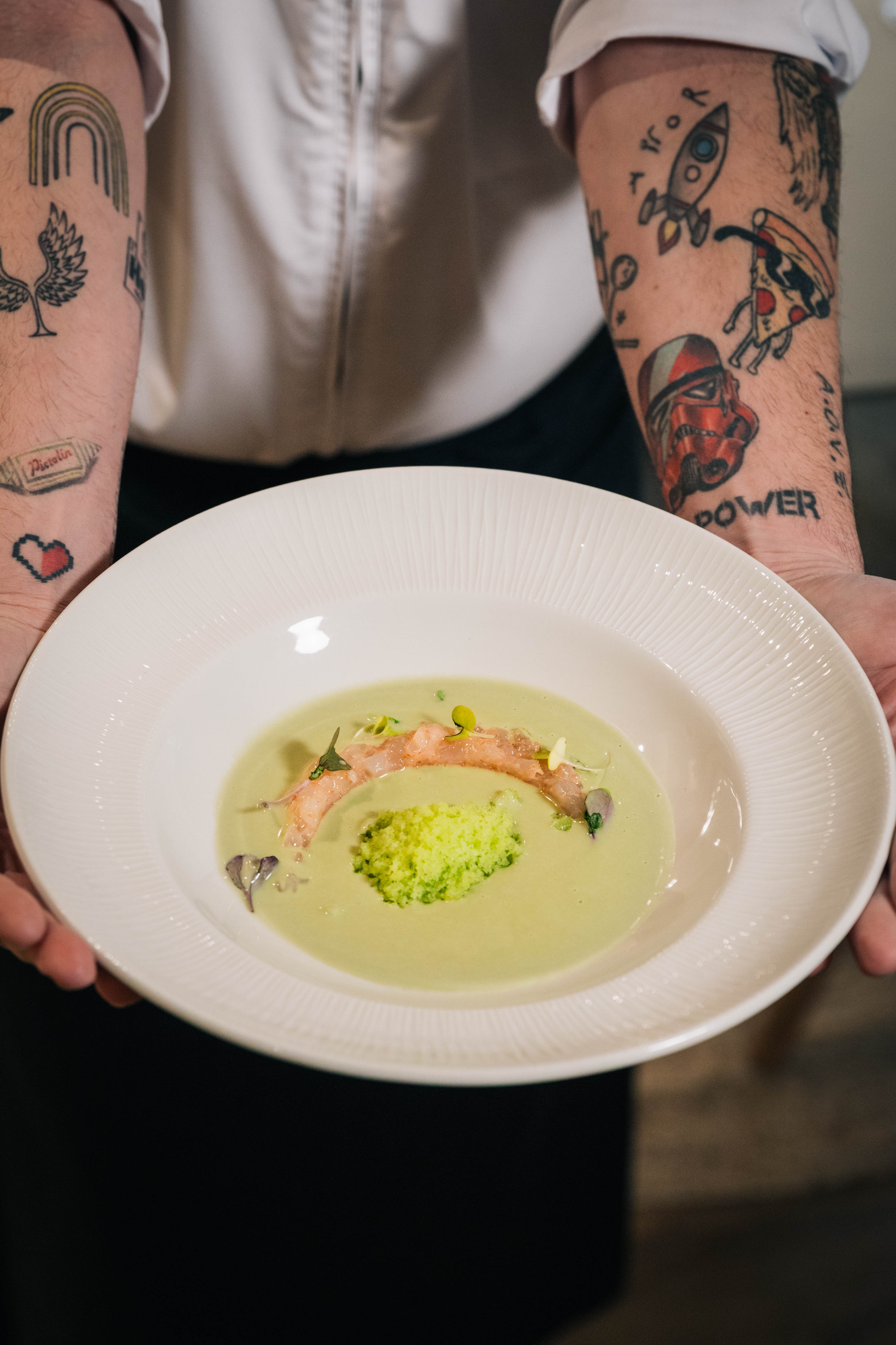 a person holding a plate of soup