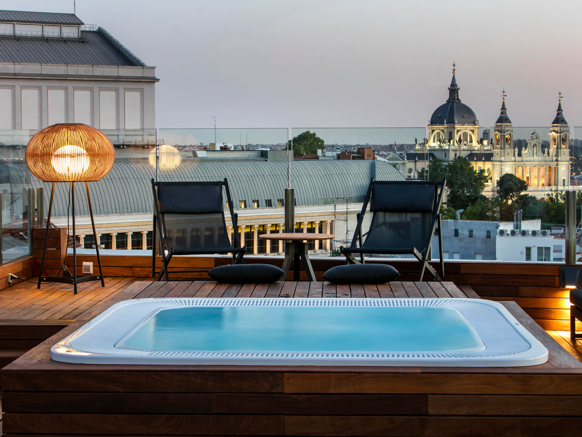 a hot tub on a deck accompanied by chairs and a table