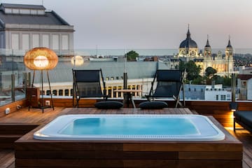 a hot tub on a deck with chairs and a table