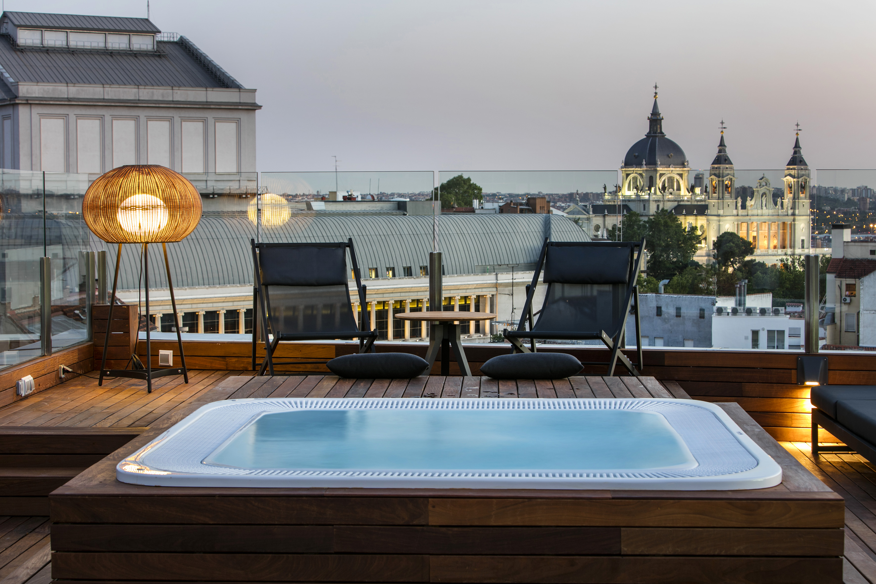 a hot tub on a deck accompanied by chairs and a table