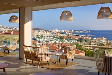 a room with chairs and a table and a view of the city