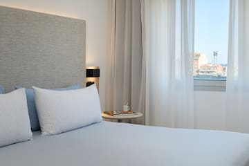 a bed with a white pillow and a table next to it