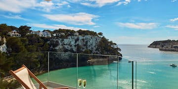 a table with two glasses of champagne on it overlooking a body of water