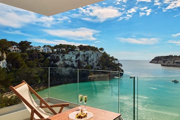 a table with two glasses of champagne on it overlooking a body of water