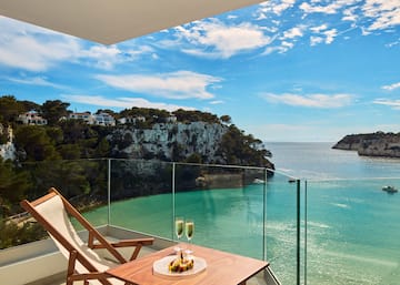 a table with two glasses of champagne on it overlooking a body of water
