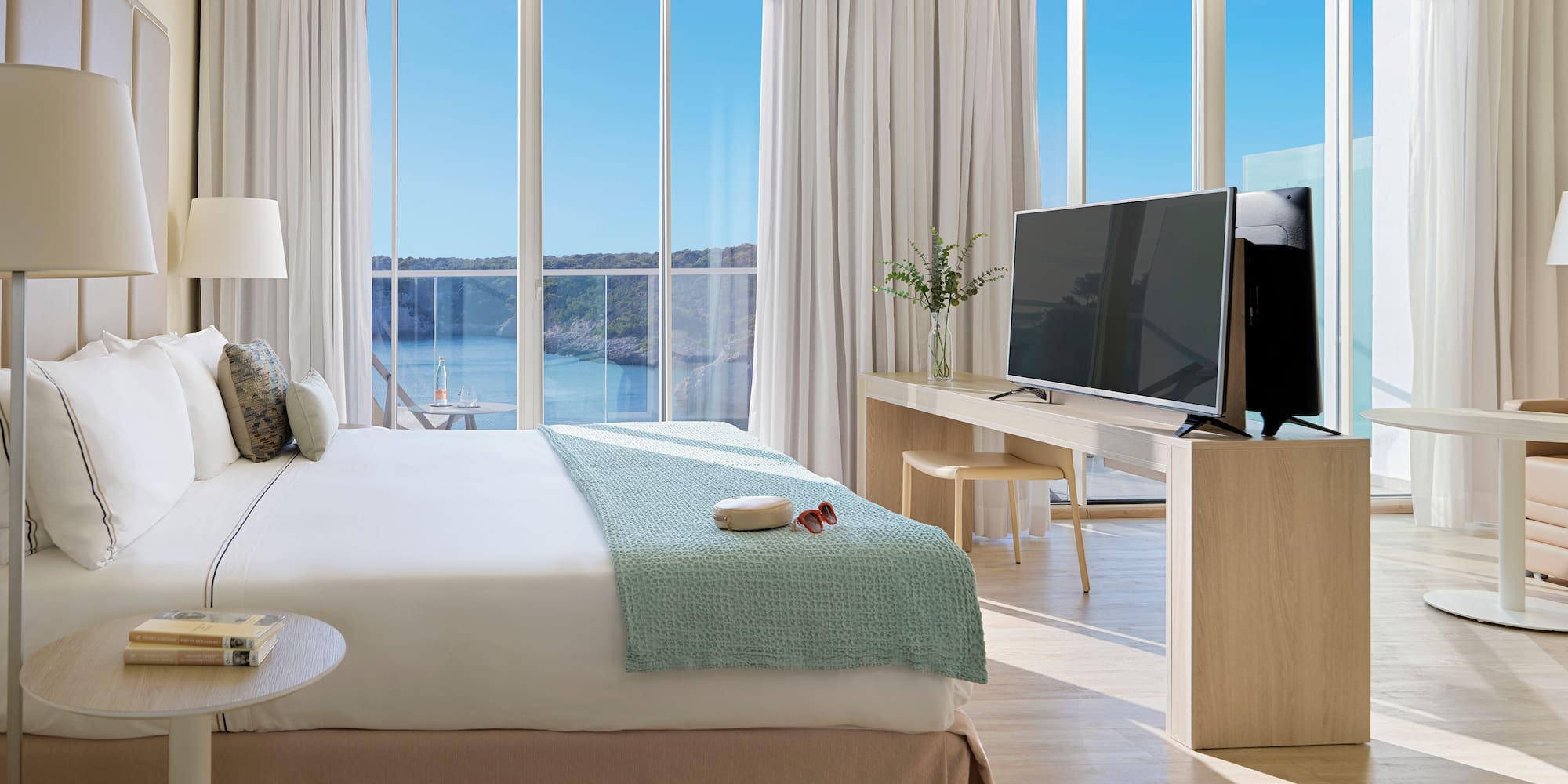 a bedroom with a television and a large window