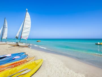 a sailboat and kayaks on a beach