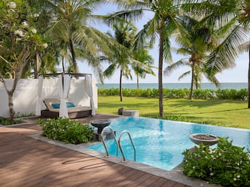 a pool with a deck and palm trees