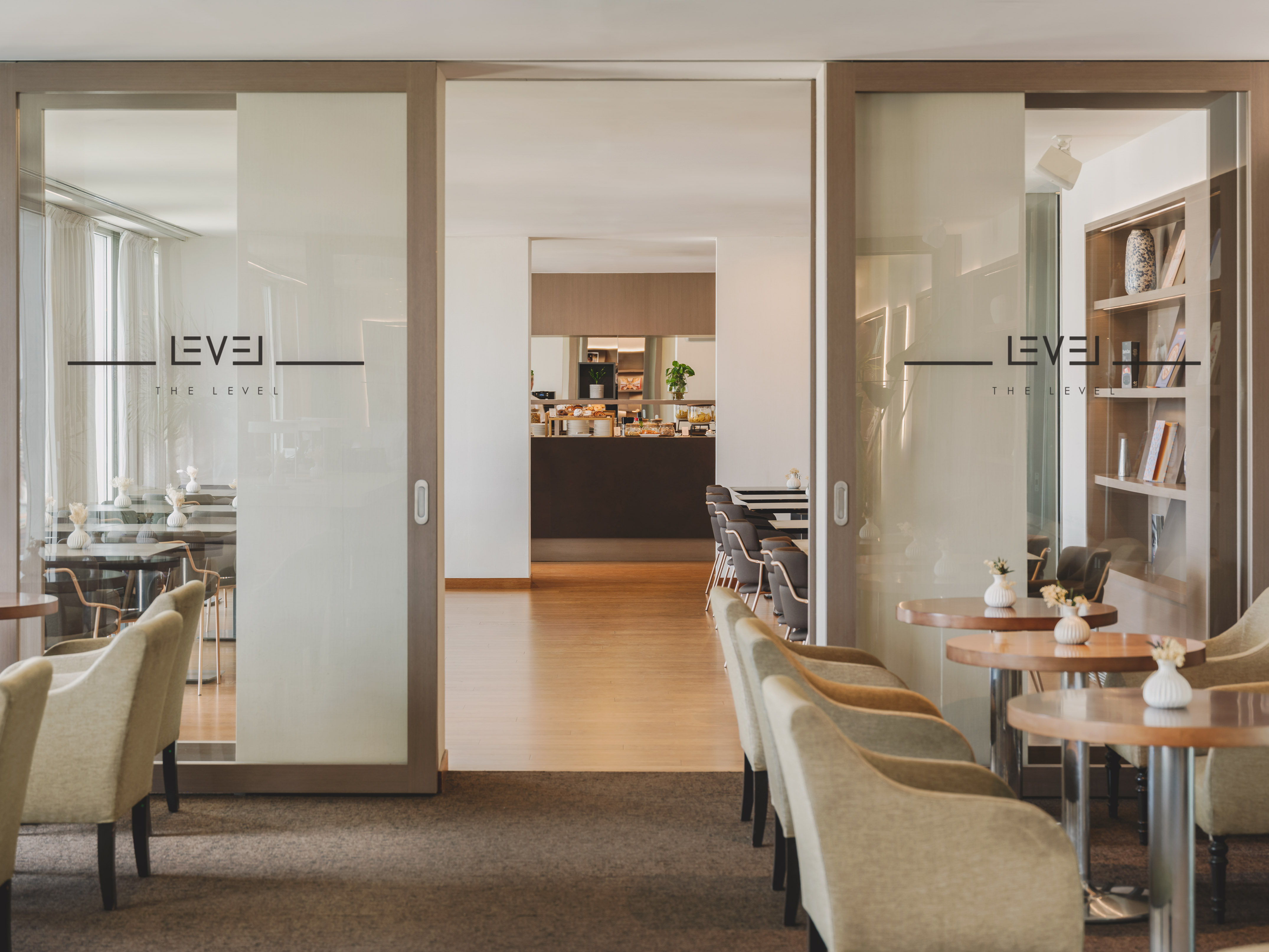 "The Level" hotel lounge, glass doors to buffet, comfortable seating.