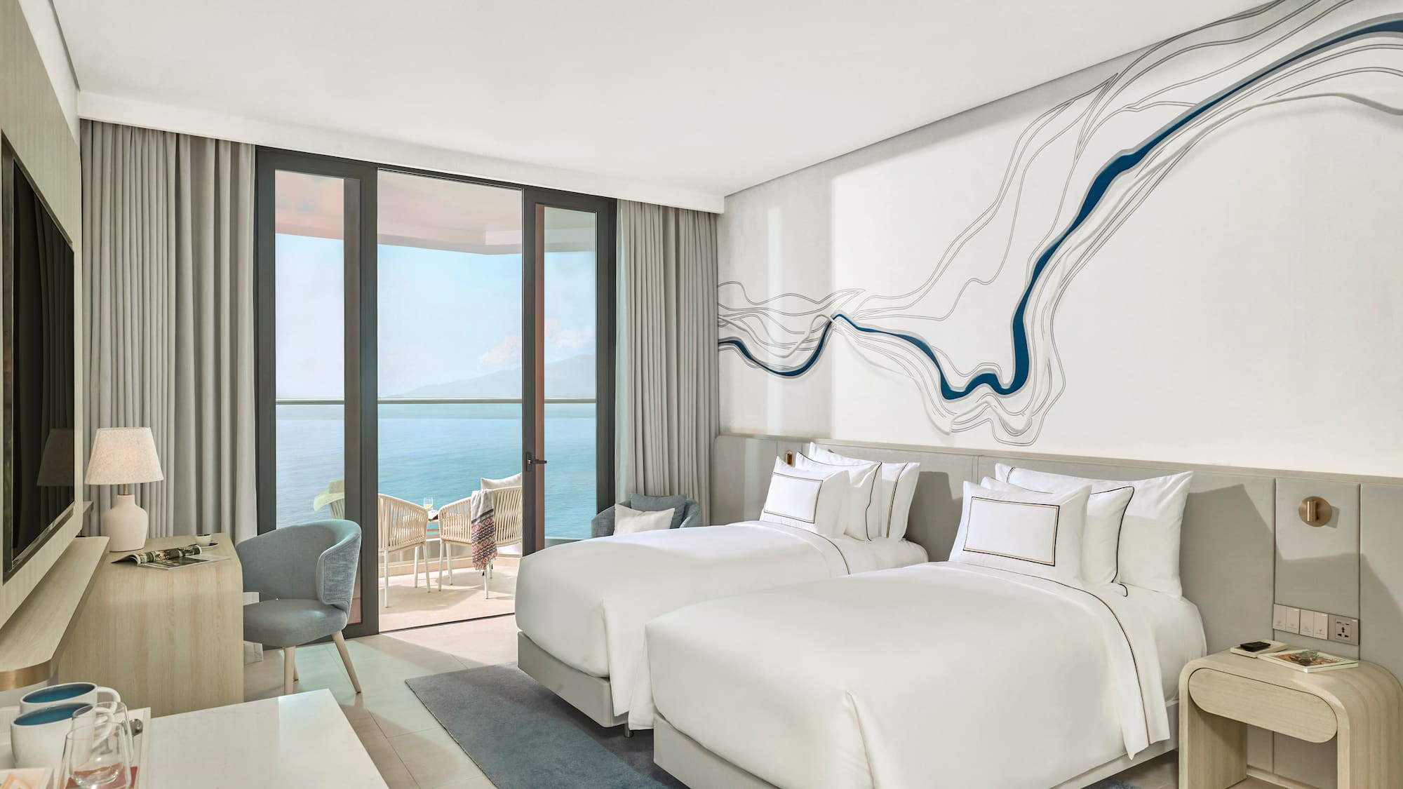 Modern ocean view hotel room with twin beds and private balcony.