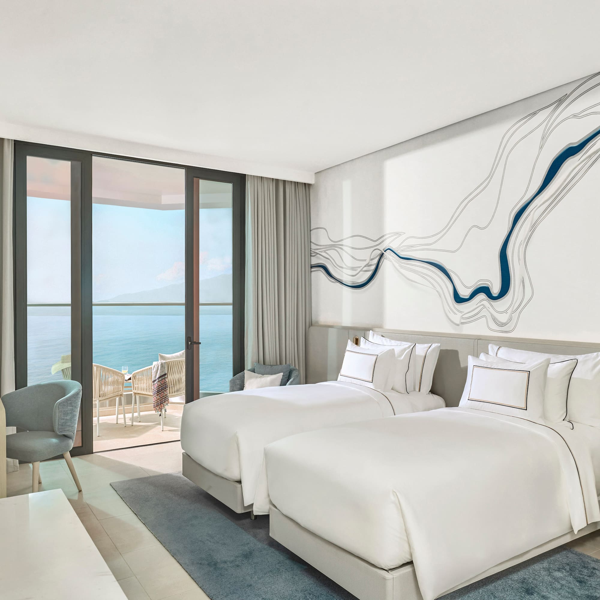 Modern ocean view hotel room with twin beds and private balcony.
