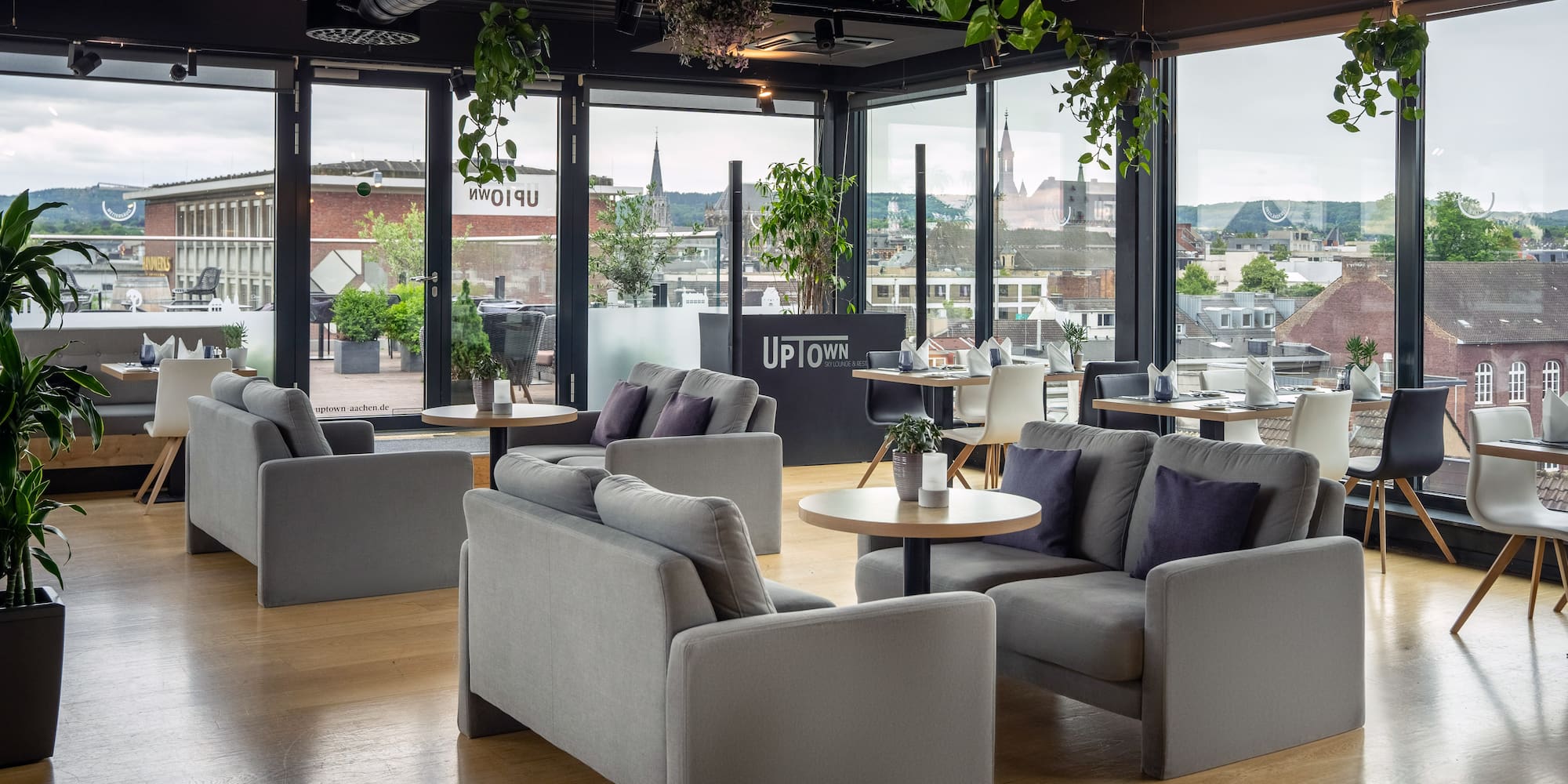 a room with couches and tables and plants