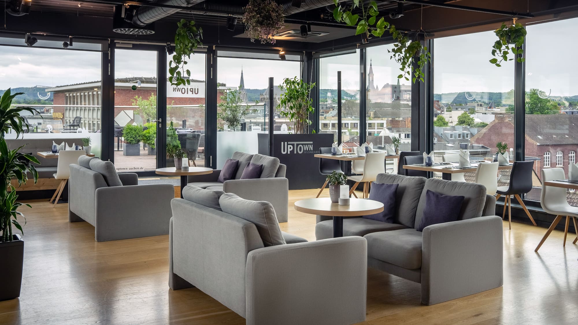 a room with couches and tables and plants